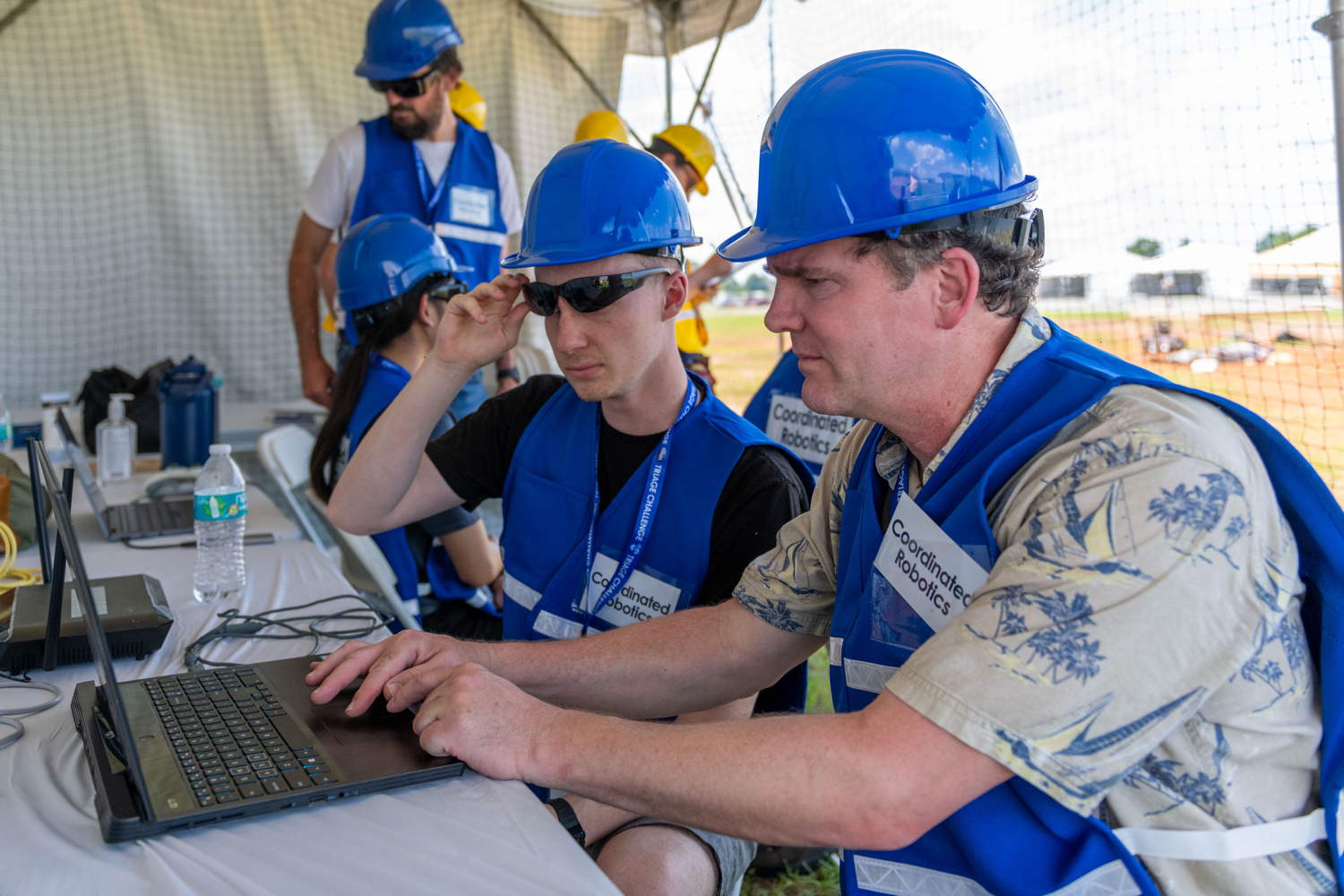 Team members collaborating on computer during practice run