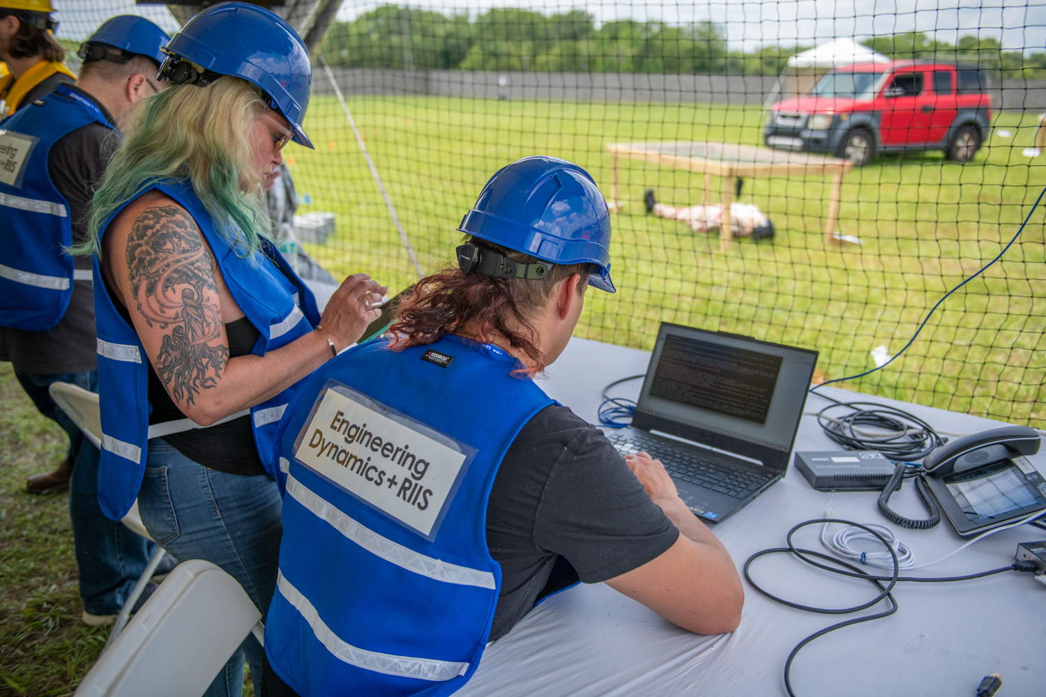 Team members collaborating on computer during practice run